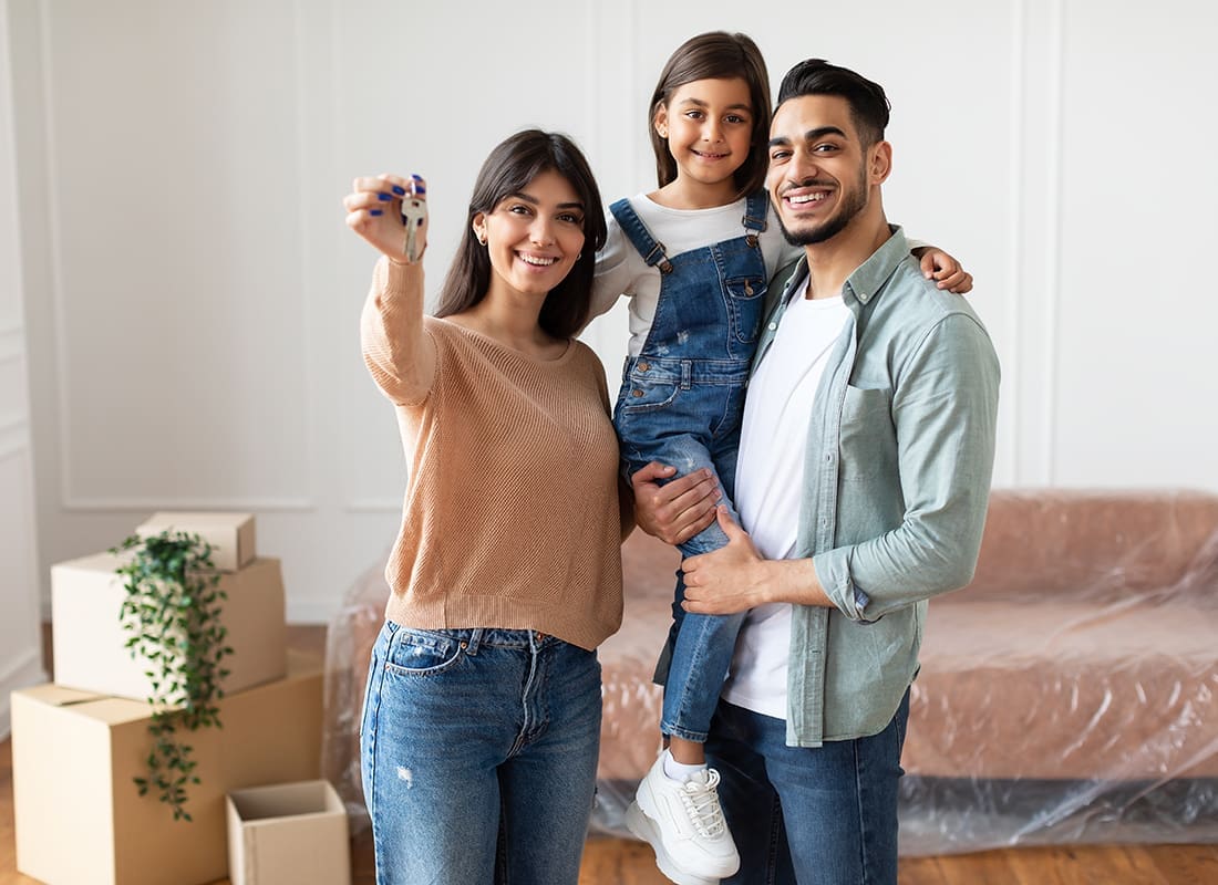 Insurance Solutions - Happy Family Holding House Keys in Their New Home