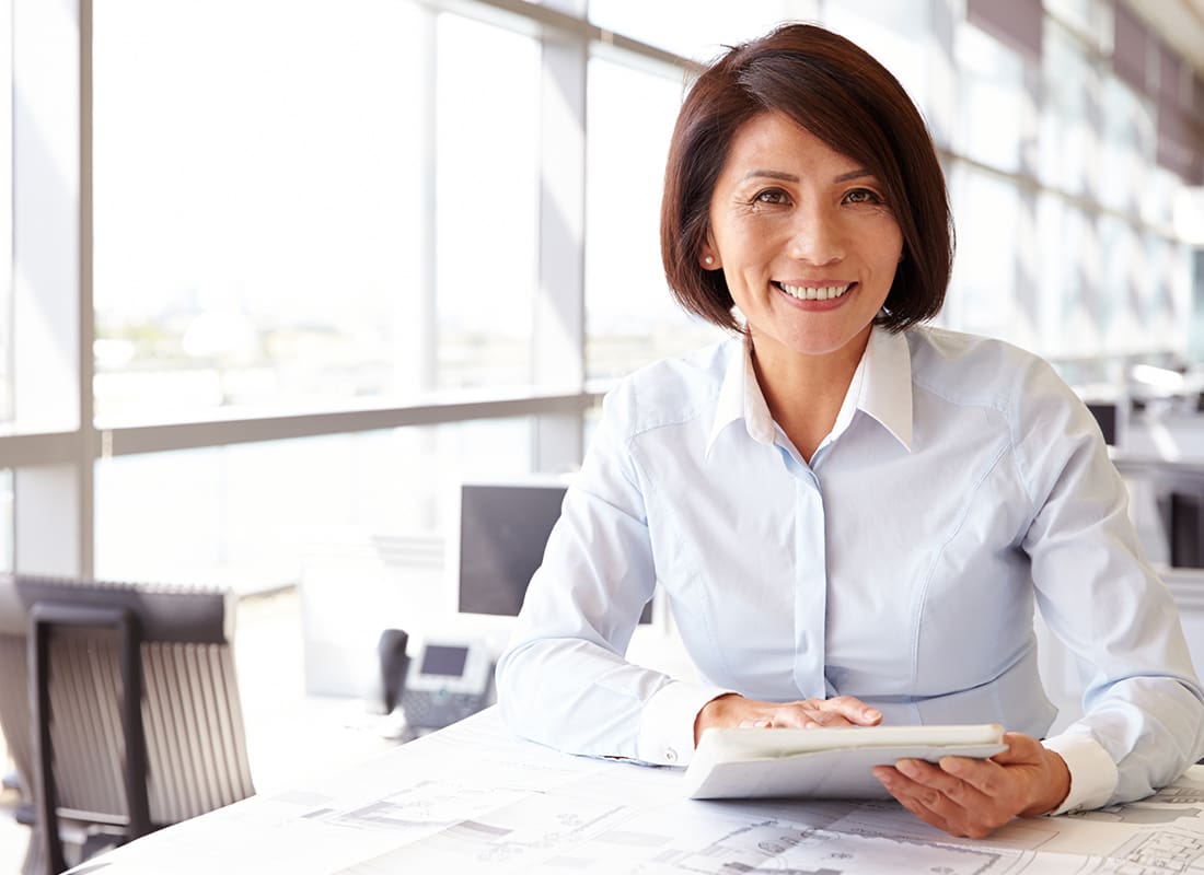Business Insurance - Cheerful Business Woman Sitting at Her Desk