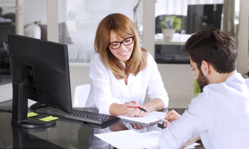 Insurance in Connecticut - Why you should declare your independence. Female insurance agent reviewing insurance policy with male client.