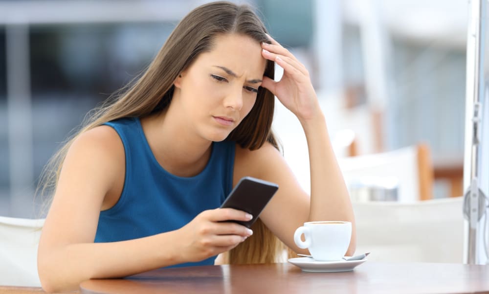 Is your insurance agent ignoring you? Woman viewing calls on mobile phone and looking frustrated
