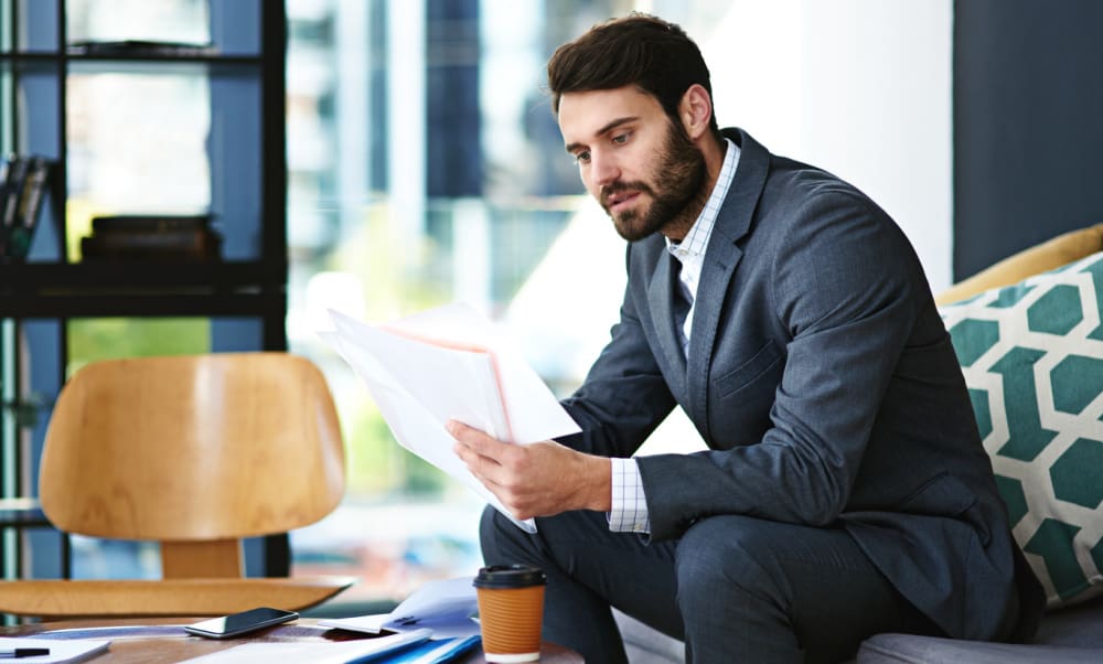 How to Lower Your Insurance Rates. Professional man reviewing insurance policies.