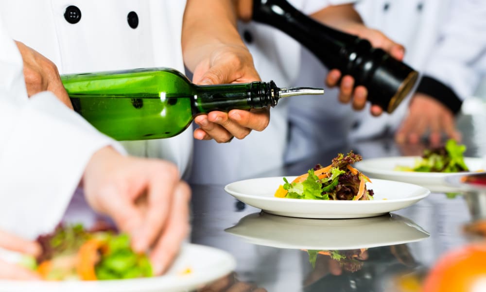 Supporting Connecticut Restaurants with Better Insurance Solutions. Asian Indonesian chef along with other cooks in restaurant or hotel commercial kitchen cooking, finishing dish or plate.