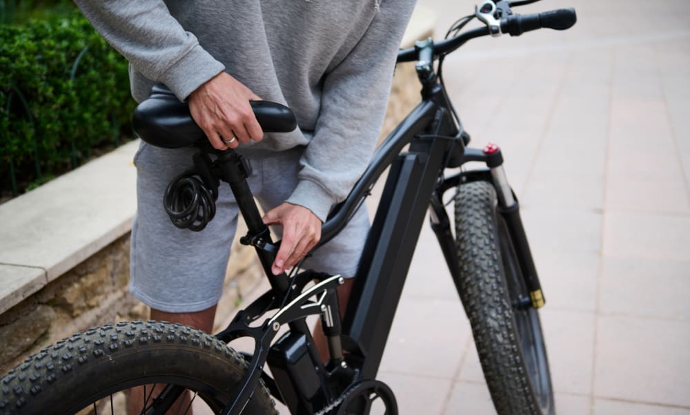 Insurance for E-Bikes and Pedal-Assisted Microcars in Connecticut. Man adjusting seat on e-bike.